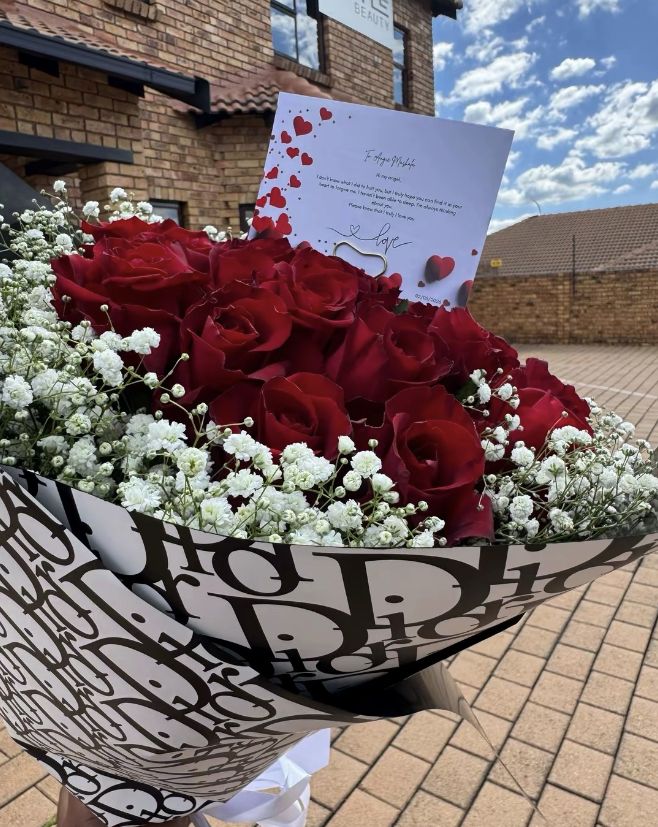 Red roses with baby's breath in a black and white premium wrap